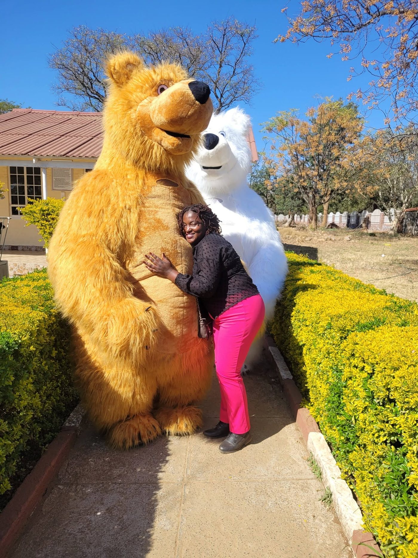 A guest hugging one of the Santi Mascots costumed characters outdoors